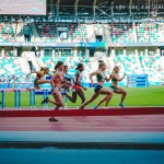 Gara di donne runner su pista da corsa